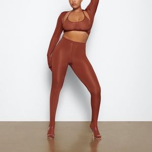 Skims saffron jelly sheer footed leggings and halter top bra.